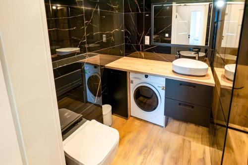 a bathroom with a washing machine and a washer and dryer at Czarna Perła Hel in Hel