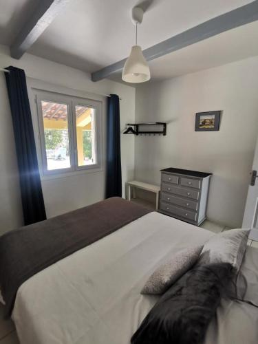 une chambre avec un grand lit et une fenêtre dans l'établissement Le cigalon, à Saint-Maximin-la-Sainte-Baume
