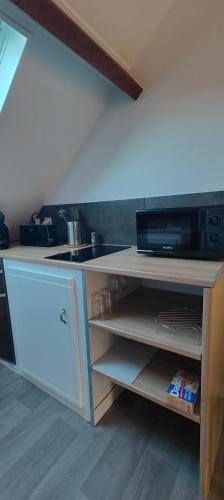 un comptoir de cuisine avec un micro-ondes et un évier dans l'établissement confort et tranquillité à Fougères - studio tout équipé, à Fougères