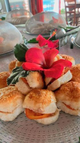 a plate of sandwiches with red flowers on it at Chez Max Pousada in Morro de São Paulo