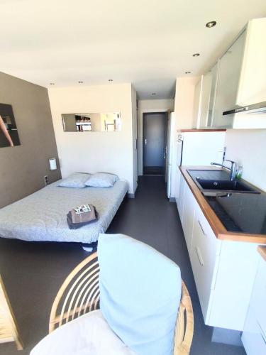 une petite chambre avec deux lits et une cuisine dans l'établissement Naturiste Cap d'Agde Port Vénus 212, au Cap d'Agde
