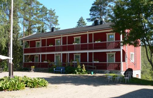 a large red house with chairs and tables in front of it at Viljamaan kartano in Kortteinen