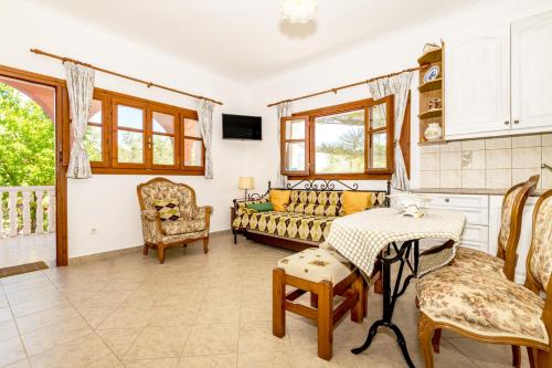 a living room with a couch and a table and chairs at Arazzo Apartments in Vasilikos