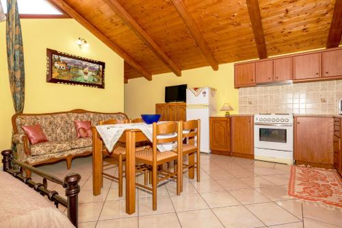 a kitchen and dining room with a table and a couch at Arazzo Apartments in Vasilikos