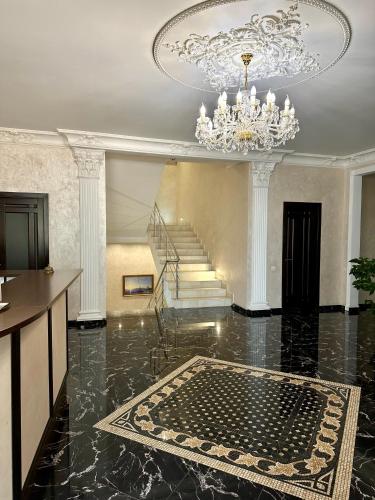 a large room with a chandelier and a staircase at VLG Hotel in Boryspilʼ