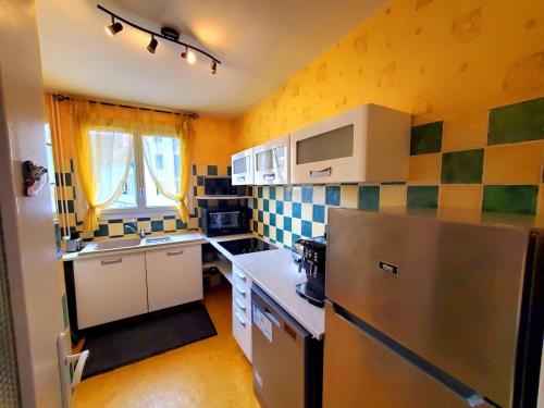 une petite cuisine avec un réfrigérateur et un évier dans l'établissement Appartement - 57m2 - Montluçon Centre Ville, à Montluçon