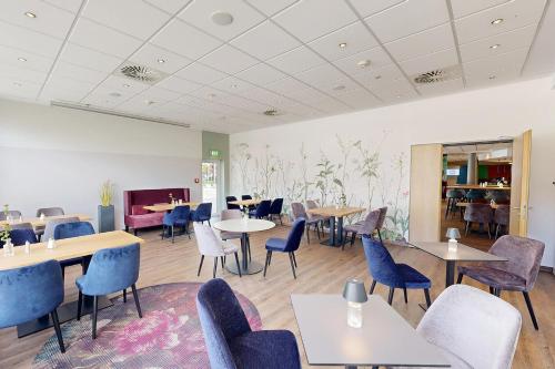a dining room with tables and chairs and tablesktop at Median Hotel Hannover Messe in Hannover