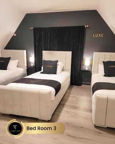 a bedroom with two beds with black and white pillows at Luxury 4 Bed Room House, Heathrow in Colnbrook