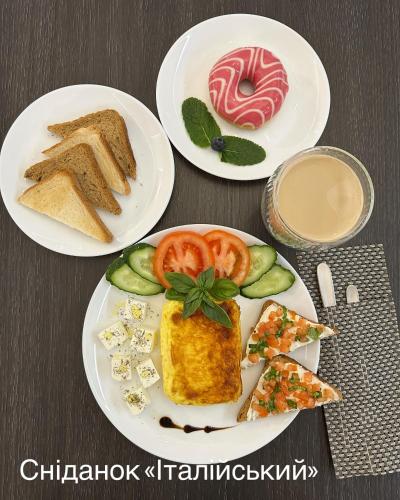 two plates of food on a table with bread and vegetables at VLG Hotel in Boryspilʼ