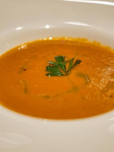 a bowl of tomato soup with a green garnishment at Villa Alizee in Port Louis
