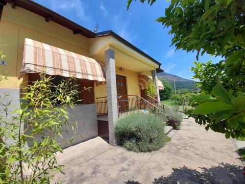 a yellow house with a porch and a balcony at Casa La V G in Almese