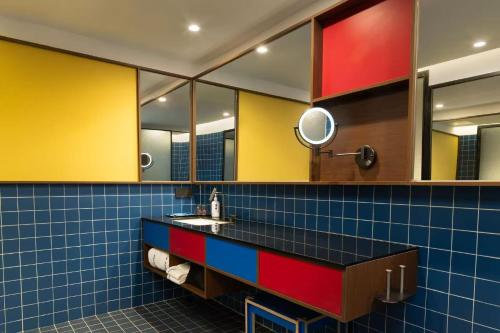 a bathroom with yellow and blue tile at 三贵三六酒店 Three Rich Hotel in Changsha