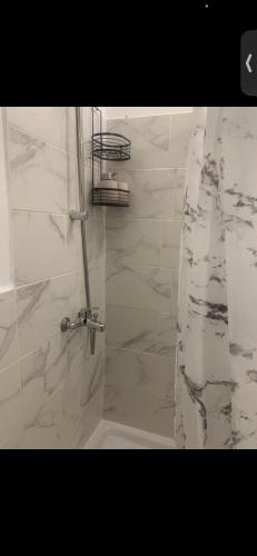 La salle de bains est pourvue d'une douche et de carrelage en marbre blanc. dans l'établissement Les 4 Studettes, à Marseille
