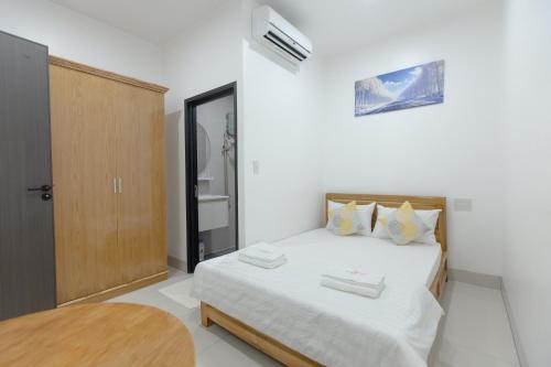 a bedroom with a bed with white sheets and pillows at Hotel AN KHƯƠNG in Rach Gia