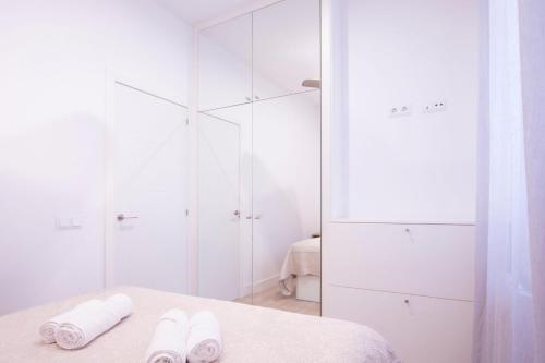 - une chambre blanche avec 2 serviettes sur un lit dans l'établissement Apartment Fomento, à Madrid