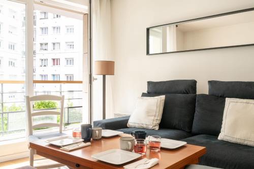 un salon avec un canapé et une table dans l'établissement Appartement Cayla - Welkeys, à Courbevoie