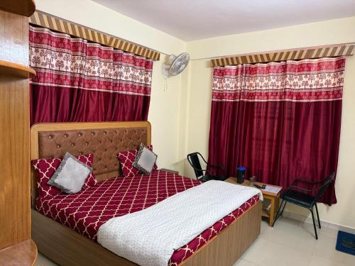 a bedroom with a bed and red curtains at Krishna Hill Stay Near Mall Road in Shimla