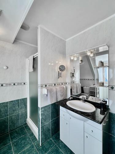 une salle de bain avec un lavabo et un miroir dans l'établissement La Roseraie, à Vitrac