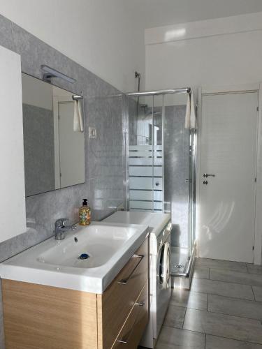 a bathroom with a white sink and a shower at Milan Suburban Escape -Family Apartment in Arcore