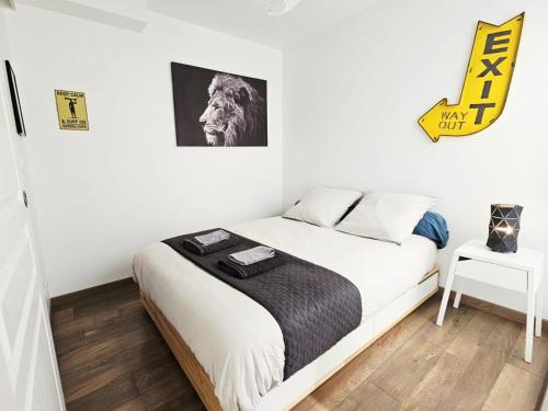 une chambre avec un lit et un tableau au mur dans l'établissement Passage Secret - Idéal Pro, Couples, Familles & Amis - Le calme en Hypercentre - Wifi Haut Débit - Netflix - Machine à laver - Gare, Cathédrale, Commerces, Restaurants & Transports en commun à moins de 10 Minutes à pied, à Reims