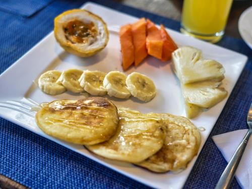 a plate of food with bananas and fruit on a table at Villa Alizee in Port Louis