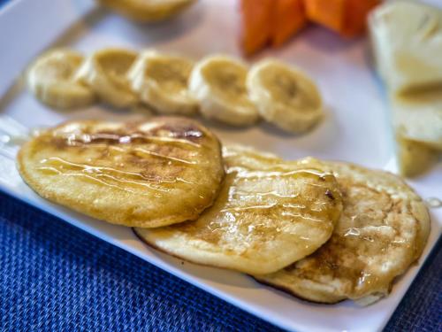 a plate of pancakes with peanut butter and banana slices at Villa Alizee in Port Louis