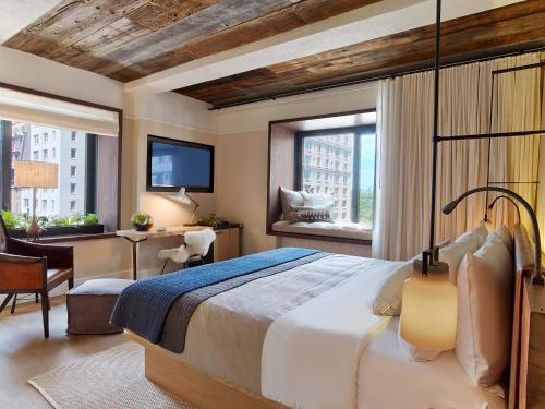 a bedroom with a bed and a desk and a tv at 1 Hotel Central Park in New York