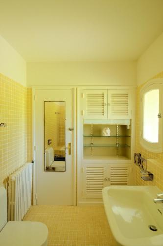 une salle de bain avec un lavabo et un miroir dans l'établissement Sur mer, à Hyères