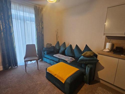 a living room with a blue couch and a chair at Apartment Mary Street in Porthcawl