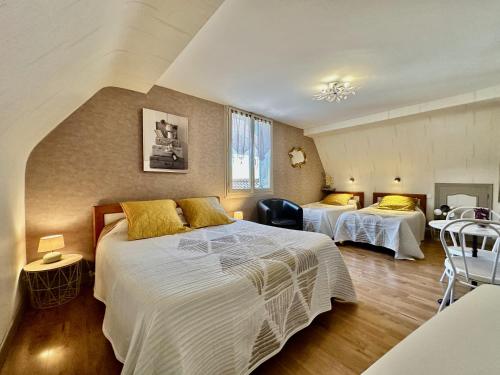 une chambre d'hôtel avec deux lits et une table dans l'établissement La Roseraie, à Vitrac