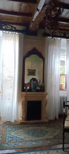 a living room with white curtains and a fireplace at Lacetoliera Residenza d'epoca in Bosco Marengo