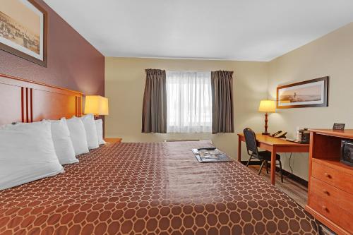 a hotel room with a large bed and a desk at Bowman Lodge & Convention Center in Bowman