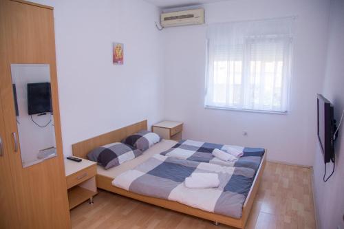 a bedroom with a bed and a television in it at Guesthouse Bajric in Mostar