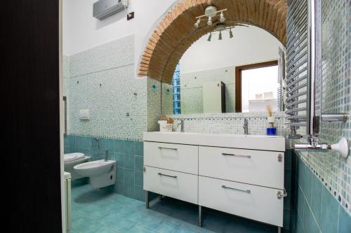 a bathroom with a sink and a toilet and a mirror at Casa Mìmì in Rieti