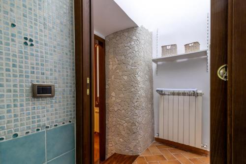 a bathroom with a walk in shower and blue tiles at Casa Mìmì in Rieti