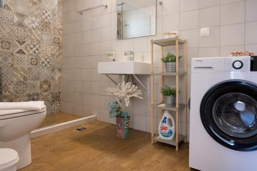 een badkamer met een wasmachine en een wastafel bij Finestrini in Preveza