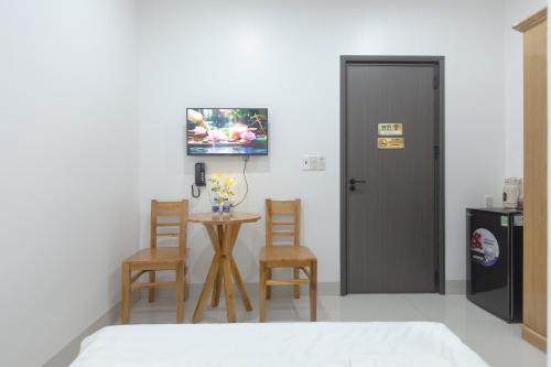 a room with a table and two chairs and a television at Hotel AN KHƯƠNG in Rach Gia