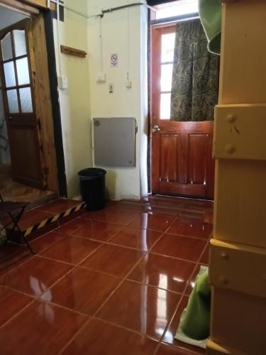 an empty room with a door and a tiled floor at Hostal Sonchek in San Pedro de Atacama