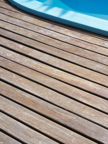 a wooden deck with a boat in the background at Villa Alizee in Port Louis