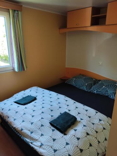 une chambre avec un lit avec deux oreillers dessus dans l'établissement Mobil Home for chilling out Camping Park ***, à Foix