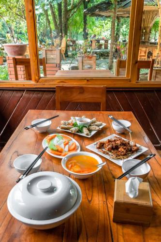 a wooden table with plates of food on it at Sapa Riverside Homestay in Sa Pa