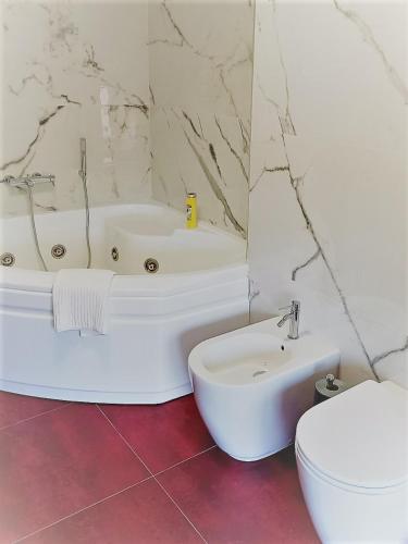 a white bathroom with a tub and a toilet at Centro Stazione Attico in Turin