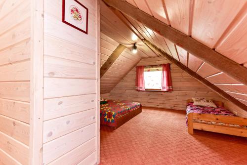 a attic room with a bed and a window at House in Krikstonys in Krikštonys