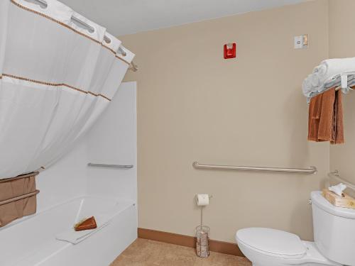a white bathroom with a toilet and a shower at Bowman Lodge & Convention Center in Bowman