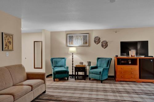 a living room with a couch and two chairs and a tv at Bowman Lodge & Convention Center in Bowman