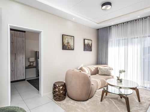 a living room with a couch and a table at Thetan's Home Away From Home in Midrand