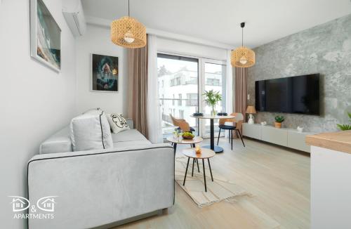 a living room with a couch and a tv at Milano 18 D&D Apartments in Międzywodzie