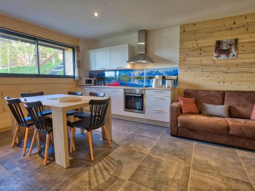une cuisine avec une table, des chaises et un canapé dans l'établissement Charmant appart. au pied des pistes, proche centre, avec terrasse, casier à skis et parking - FR-1-505-106, à Crest-Voland