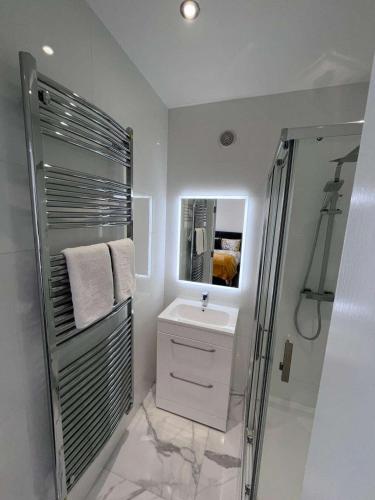 a white bathroom with a sink and a shower at The Earls in Newry