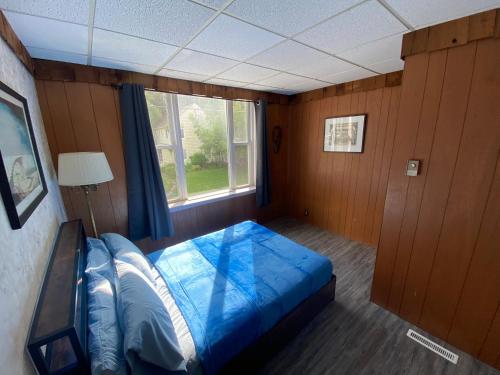 - une chambre avec un grand lit bleu et une fenêtre dans l'établissement 2BR 2nd floor apartment overlooking downtown, à Elkader